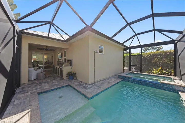 Private swimming pool featuring a bubbler shelf, patio area, pool with connected hot tub, waterfall feature, autofill, and EXTERIOR CAMERAS. New HEATED SALTWATER POOL & SPA (May 2022)