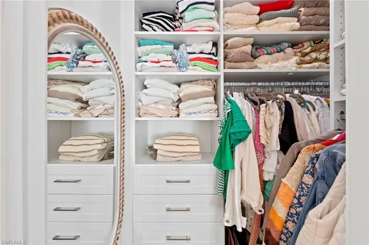 Walk-in closet located in the secondary bedroom. New added CAN LIGHTING (September 2023), new CUSTOM CLOSET ORGANIZERS (February 2022), new SISAL CARPET (February 2022)