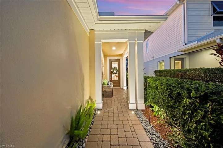 Beautifully lit and welcoming entry with LANDSCAPE LIGHTING, UPLIGHTING, and VIDEO DOORBELL.