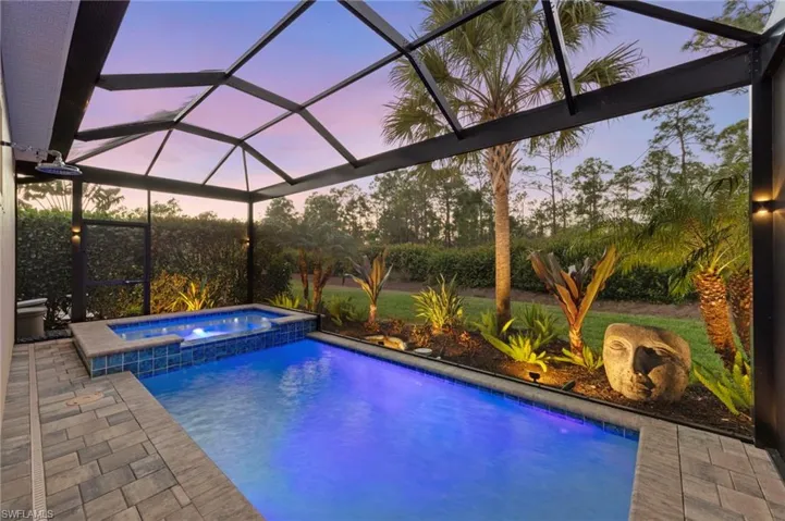 Custom cage sconce lighting helps define the PICTURE FRAME SCREEN CAGE and landscape uplighting highlights the lush landscaping.