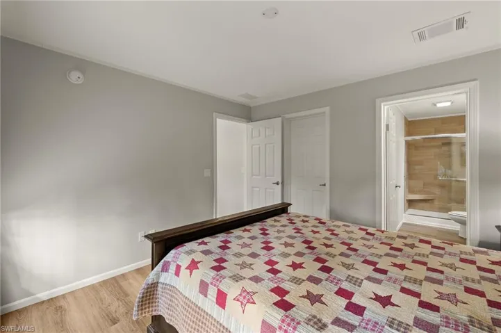 Bedroom featuring light wood-type flooring and ensuite bath