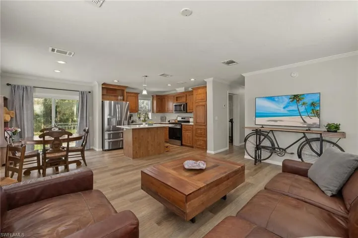 Living room with light wood-type flooring and crown molding
