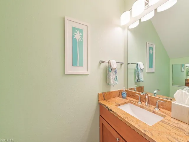 Bathroom with lofted ceiling and vanity
