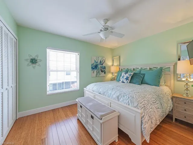 Bedroom with ceiling fan, a closet, light wood-type flooring, and baseboards