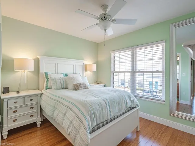 Bedroom featuring wood finished floors, a ceiling fan, and baseboards