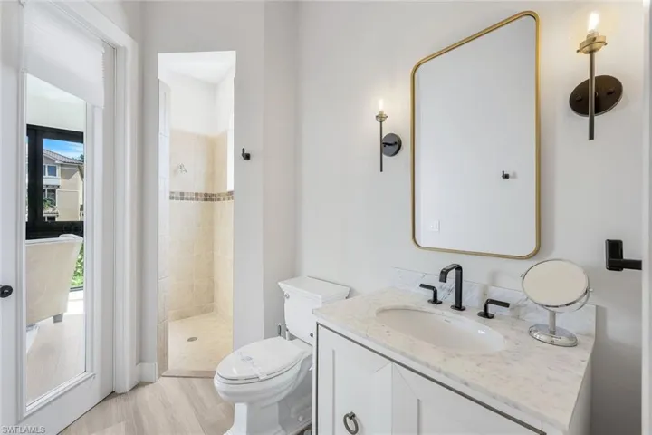 Full bathroom with vanity, a shower stall, and light wood-style flooring