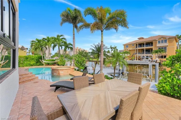 View of swimming pool featuring a patio, a pool with connected hot tub, and a water view