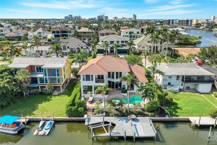 Drone / aerial view of a nearby body of water and a pool area