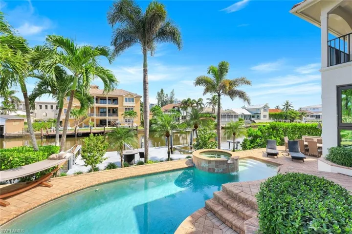 View of pool with a residential view, a patio area, a pool with connected hot tub, and a water view