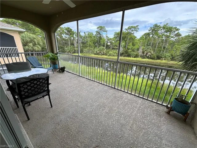 Sunroom / solarium with a water view and view of wooded area