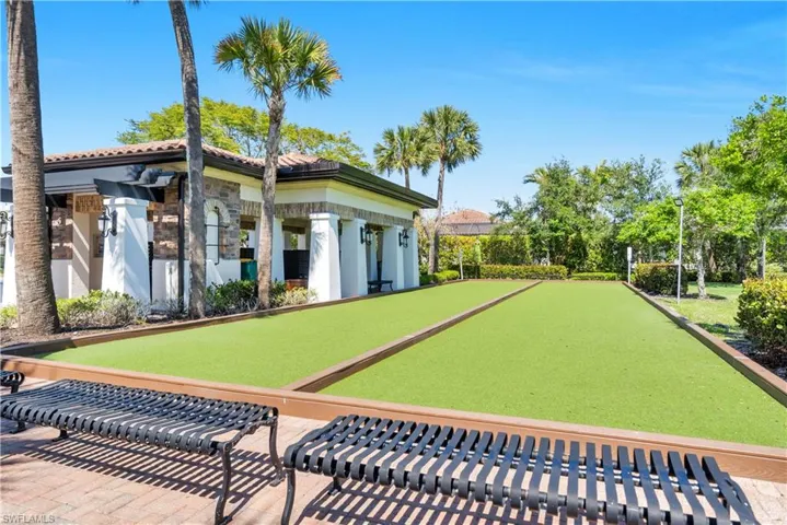 Dual bocce ball courts featuring artificial turf surfaces and surrounding paver pathways
