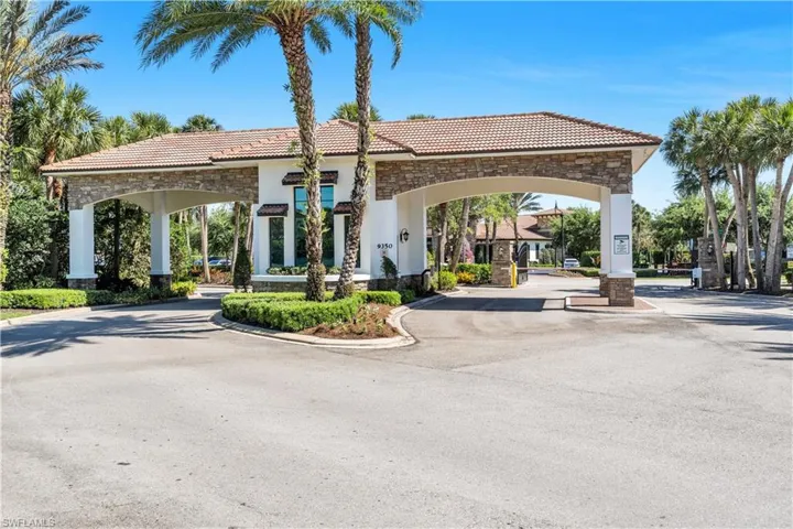 Architectural entry gate featuring a tile roof, stone accents, and white columns