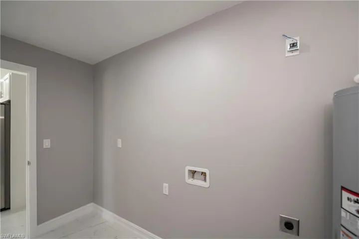 Clothes washing area featuring washer hookup, marble finish floor, hookup for an electric dryer, laundry area, and baseboards