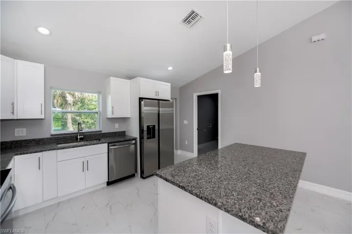 Kitchen with marble finish floor, stainless steel appliances, recessed lighting, visible vents, and a sink
