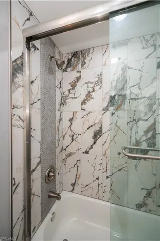 Bathroom with shower / bath combination with glass door