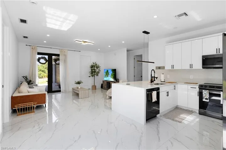 Kitchen featuring black appliances, a sink, modern cabinets, a peninsula, and open floor plan