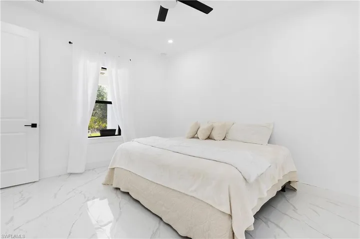 Bedroom with marble finish floors, baseboards, recessed lighting, and a ceiling fan