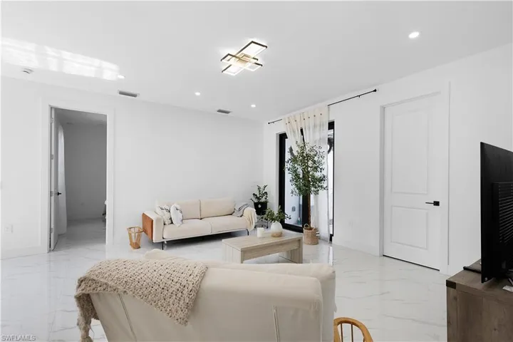 Living area with light marble finish flooring, recessed lighting, and baseboards
