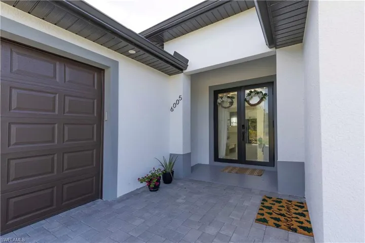 View of exterior entry featuring stucco siding, french doors, and a garage