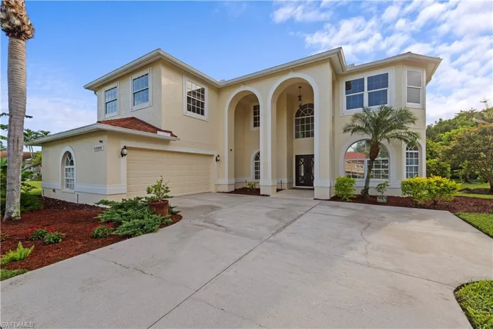 Stucco exterior with multiple arched windows and a two-story entryway