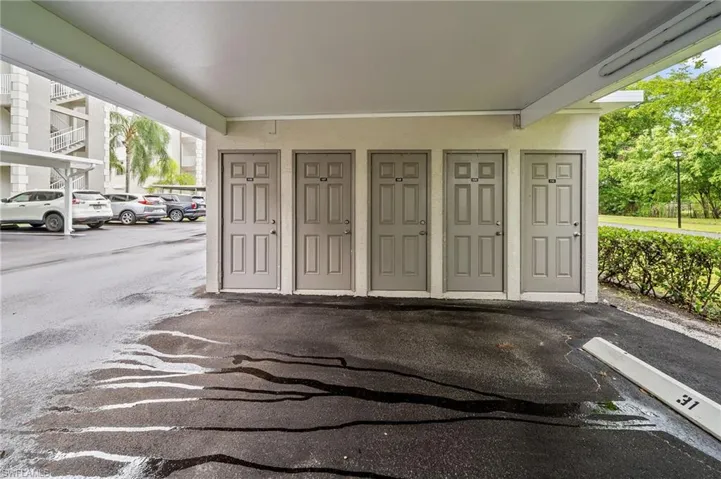 View of exterior entry with stucco siding and covered parking