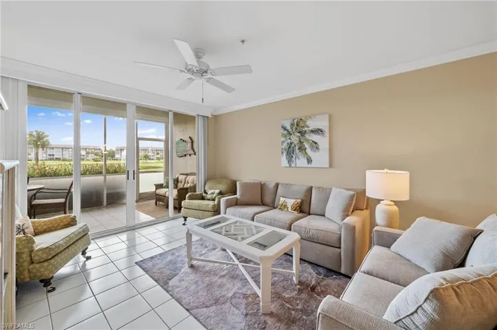 Living area featuring ornamental molding, floor to ceiling windows, tile patterned floors, and a ceiling fan
