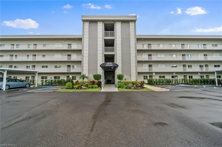 View of apartment building / complex with uncovered parking