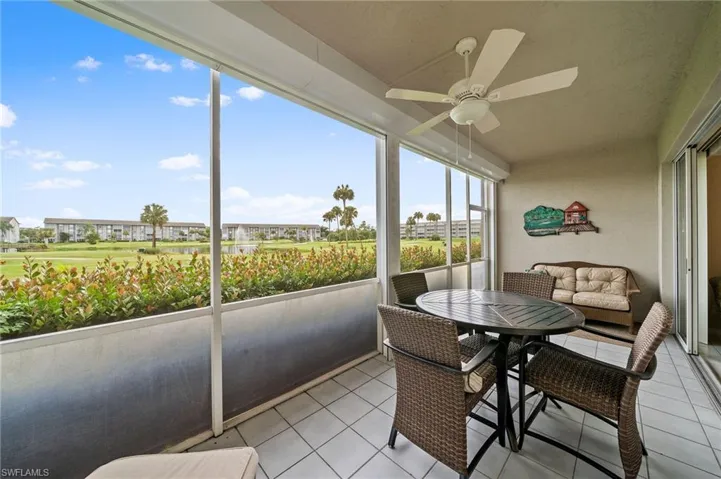 Sunroom with a ceiling fan, tile patterned flooring, and a water view