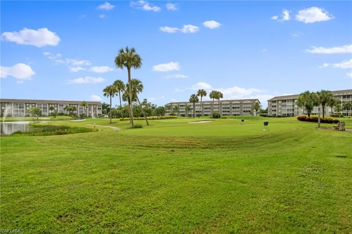 View of community featuring golf course view, a yard, and a water view