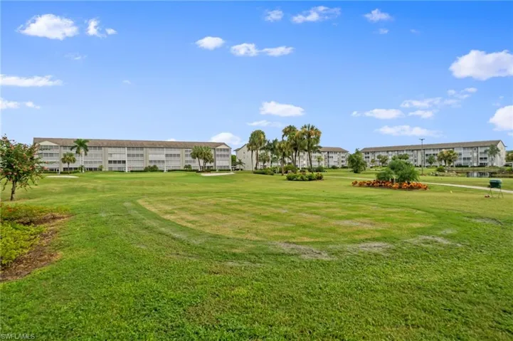 View of community with golf course view and a yard