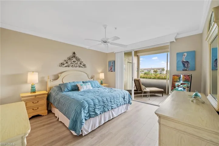 Bedroom featuring crown molding, light wood finished floors, a ceiling fan, and access to exterior