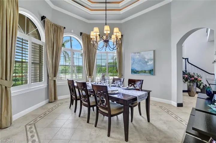 Tiled formal dining area with double tray ceiling and ample natural light.