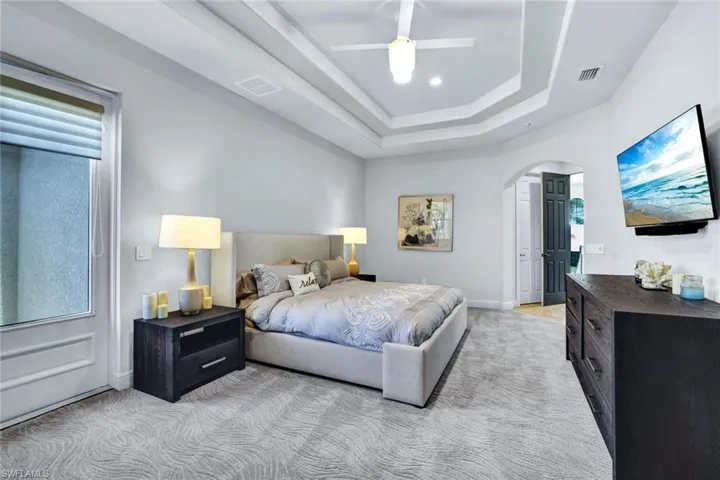 2nd Story Master Bedroom features double tray ceilings, large walk in closet and master bathroom and access to the screened balcony that overlooks the pool and canal.