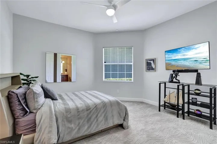 2nd Bedroom, located on 1st floor with light colored carpet and ceiling fan and ensuite bathroom