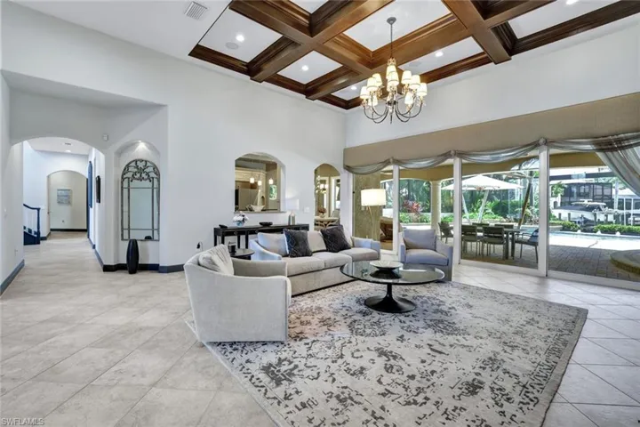 Great Room featuring chandelier, coffered ceiling, and light tile patterned floors