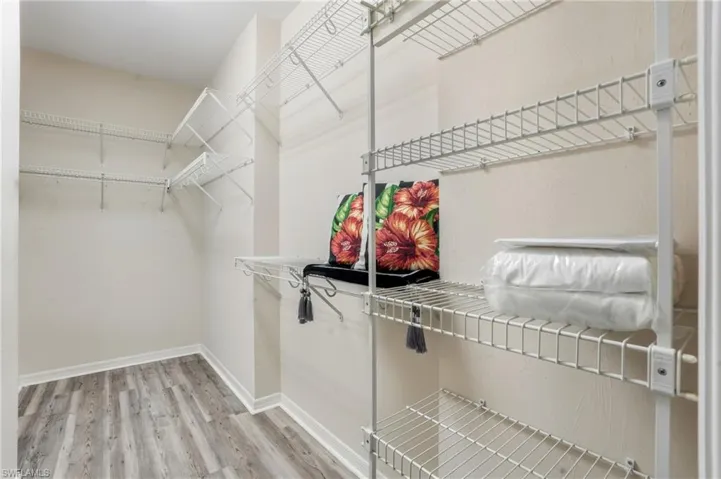 Walk in closet with light wood-style flooring