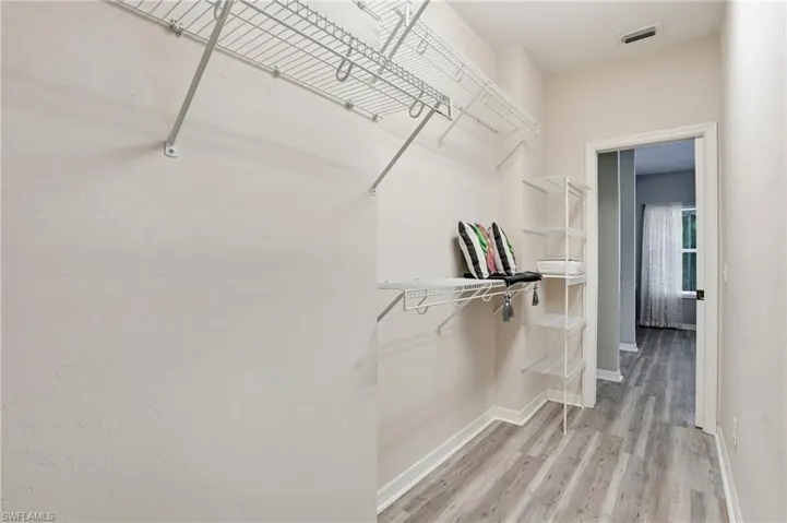 Walk in closet with light wood-style floors