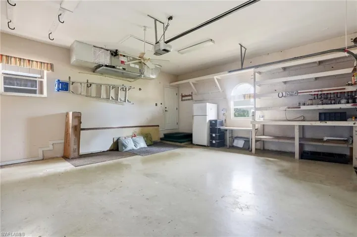Garage featuring freestanding refrigerator and a workshop area