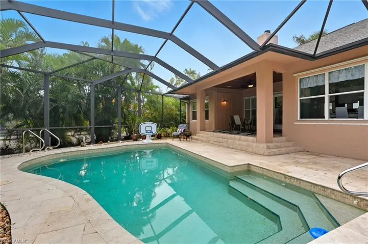 Swimming pool with a patio, glass enclosure, and a sunroom