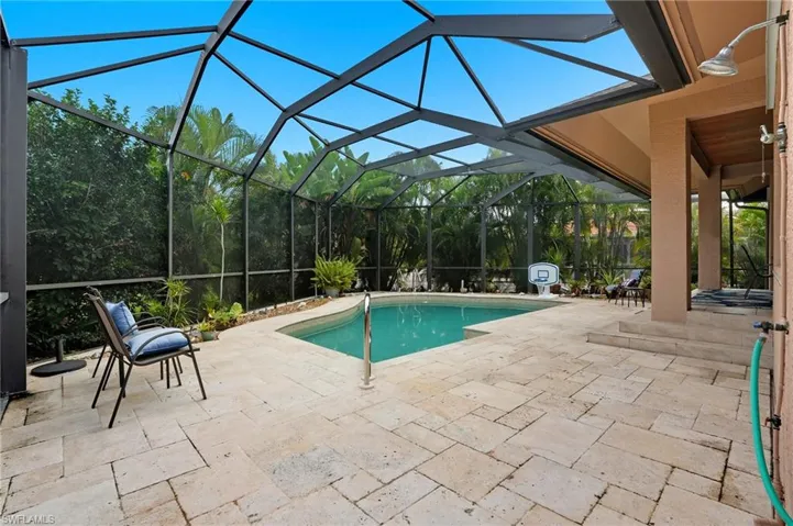 Outdoor pool with a patio area, a sunroom, and a lanai