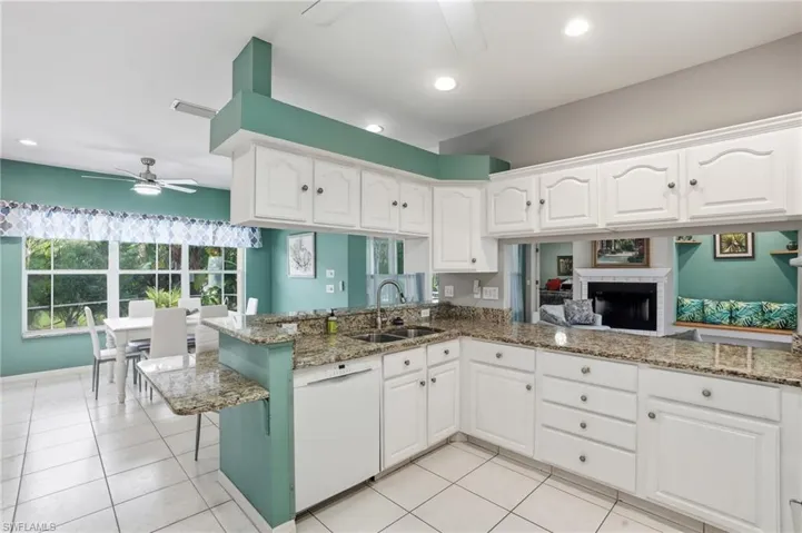 Kitchen with a ceiling fan, light stone countertops, white cabinetry, and recessed lighting