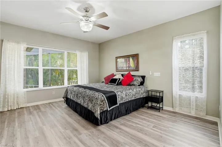 Bedroom featuring light wood-style flooring, multiple windows, and ceiling fan