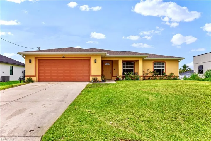 View of front of house with a garage and a front lawn