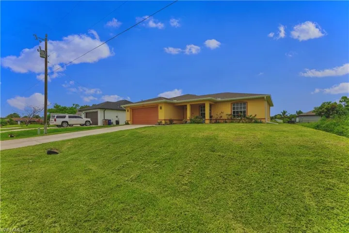 Ranch-style house with a garage and a front lawn