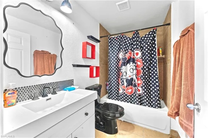 Full bathroom featuring vanity, tile patterned flooring, toilet, and shower / bath combination with curtain
