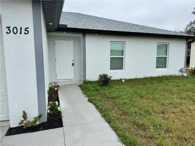 Entrance to property with a lawn