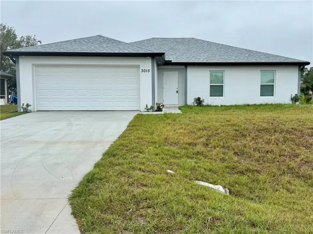 View of front of home with a garage and a front yard