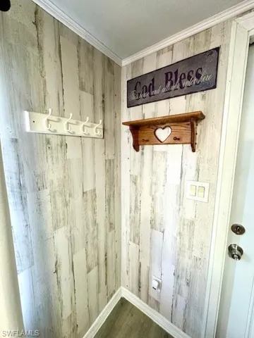 Detailed view of wood walls, wood finished floors, ornamental molding, and baseboards