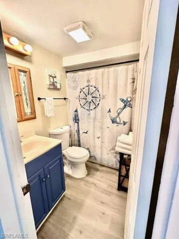 Bathroom featuring vanity, wood finished floors, and toilet
