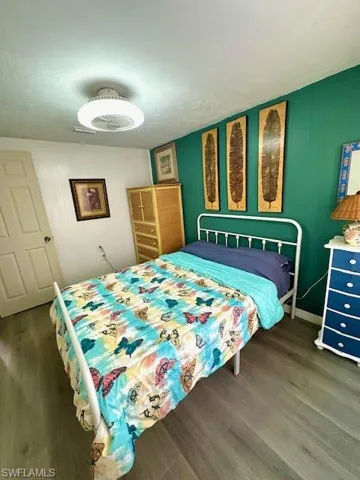 Bedroom featuring wood finished floors and baseboards